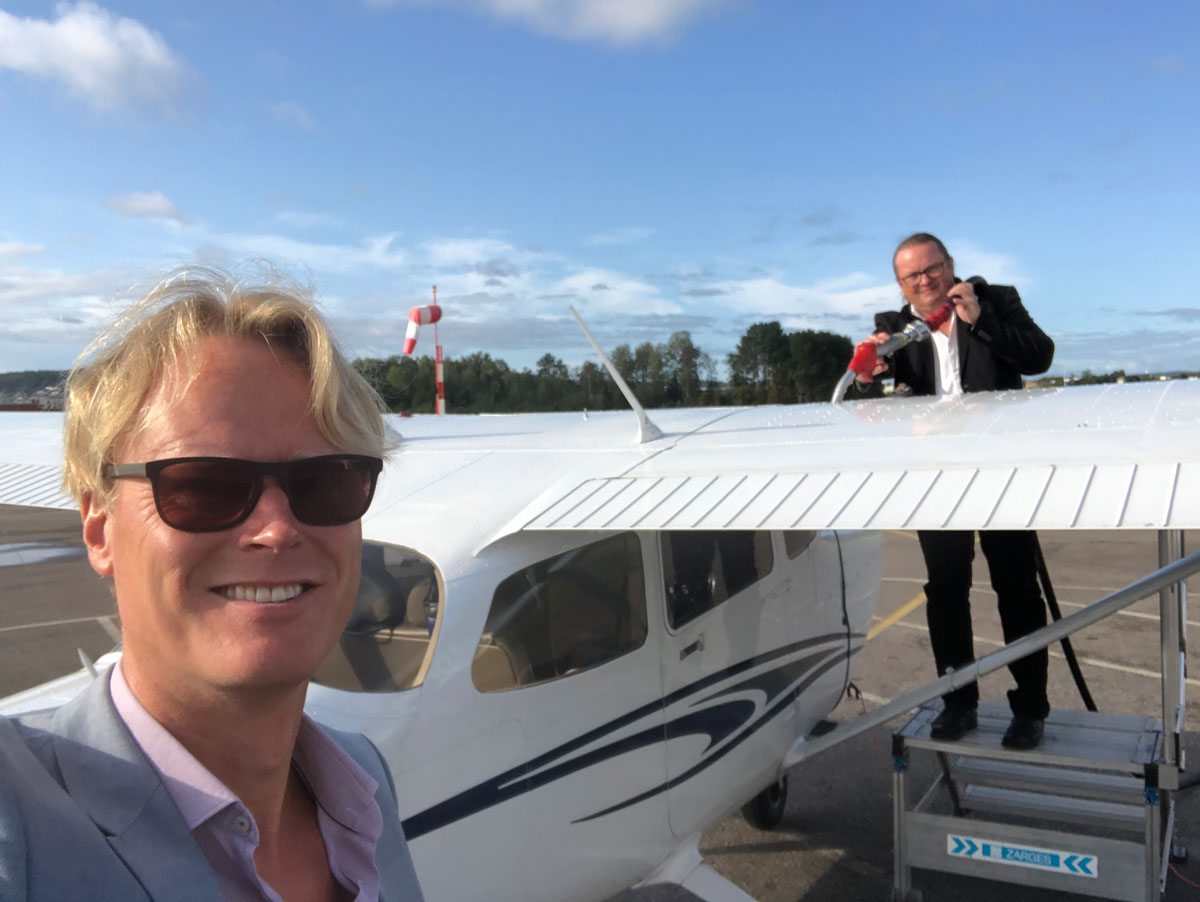 To menn tar selfie foran et småfly.