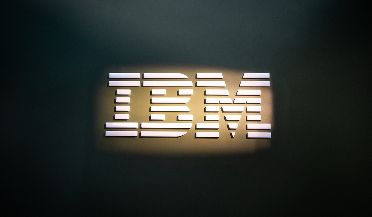 Bildet viser logoen til IBM. Logoen er i store blokkbokstaver med linjer som former bokstavene på langs. Logoen er lyst opp og bakgrunnen er mørkegrønn.