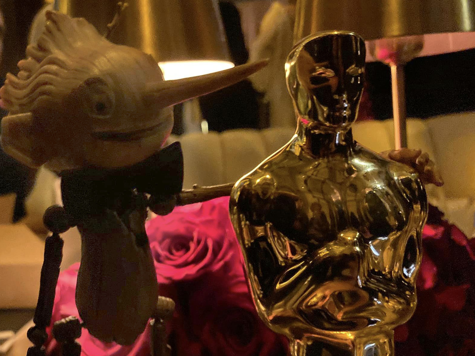 Nærbilde av Pinocchiodukken med armen rundt Oscarstatuetten