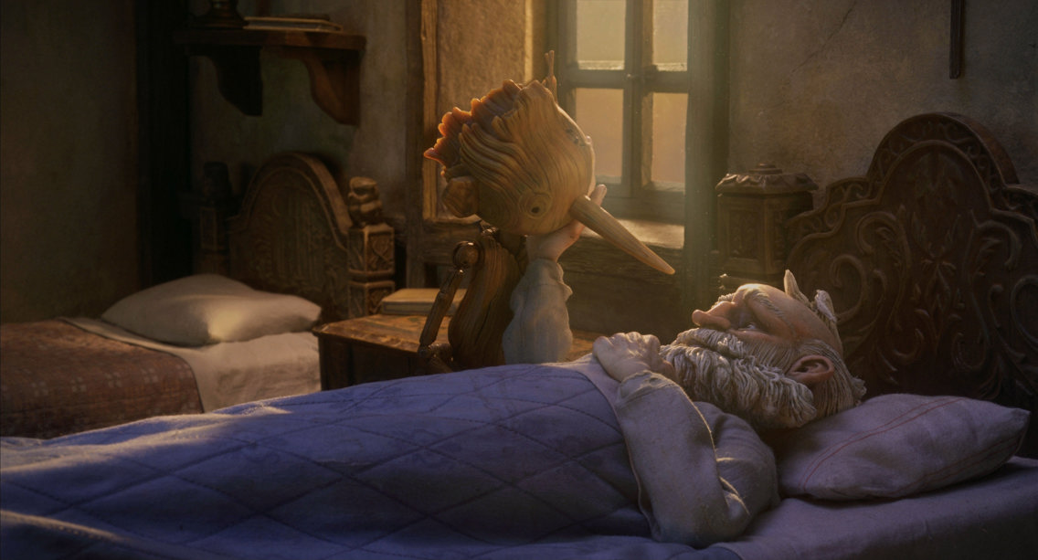 Scene fra filmen Pinocchio, der Gepetto ligger syk i sengen og kveldslys faller gjennom vinduet. 