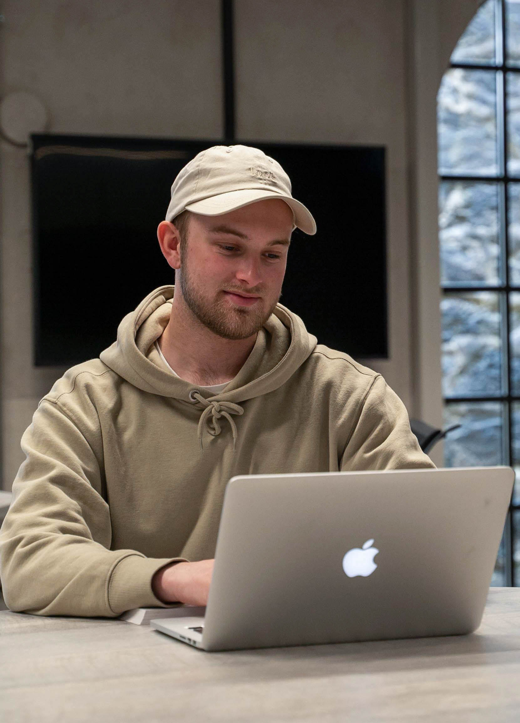 Foto av en student som sitter å ser ned på en laptop.